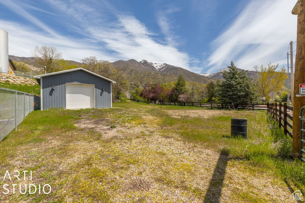 View of yard with a garage, a mountain view, and an outdoor structure