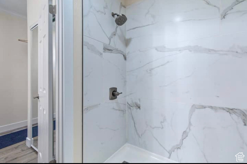 Bathroom featuring hardwood / wood-style floors and tiled shower