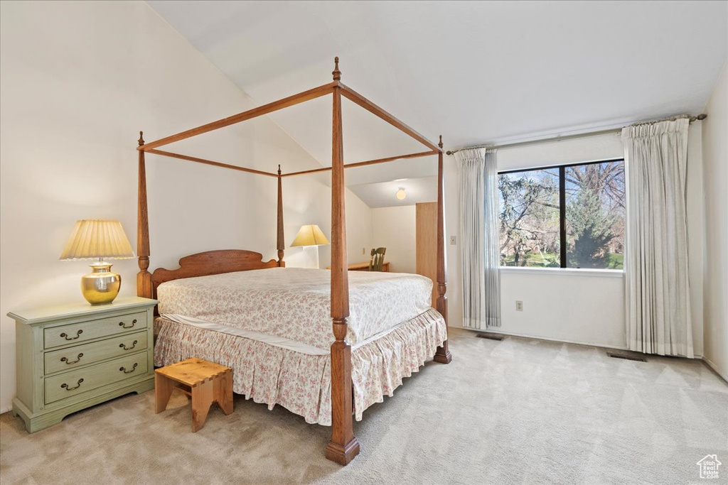 Bedroom with carpet floors and vaulted ceiling