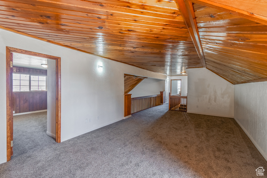 Additional living space featuring carpet floors and wood ceiling