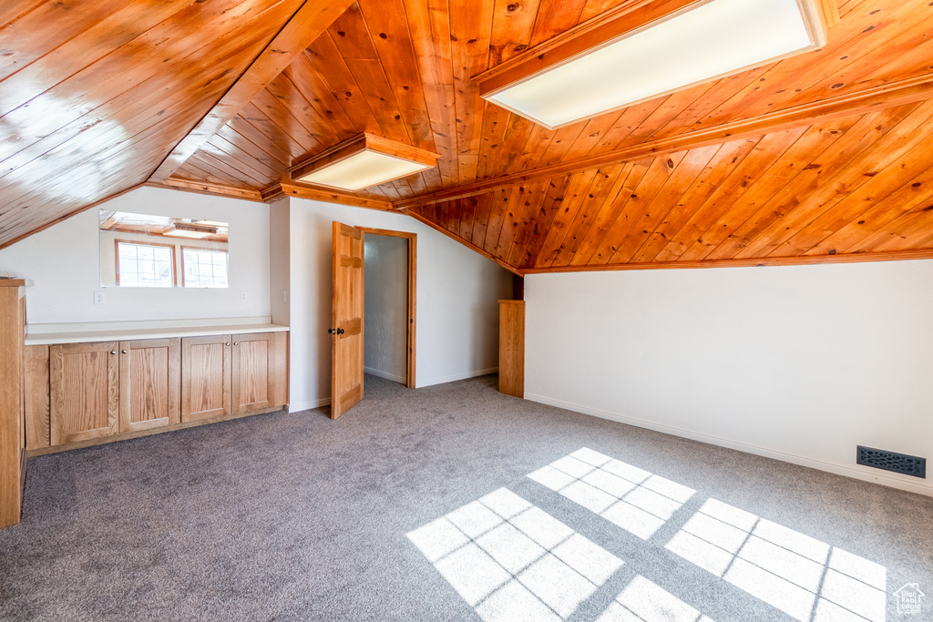 Additional living space featuring light carpet, wooden ceiling, and lofted ceiling