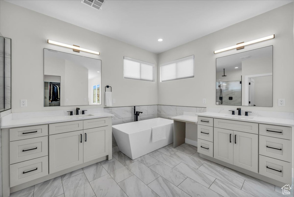 Bathroom featuring dual sinks, oversized vanity, and tile floors