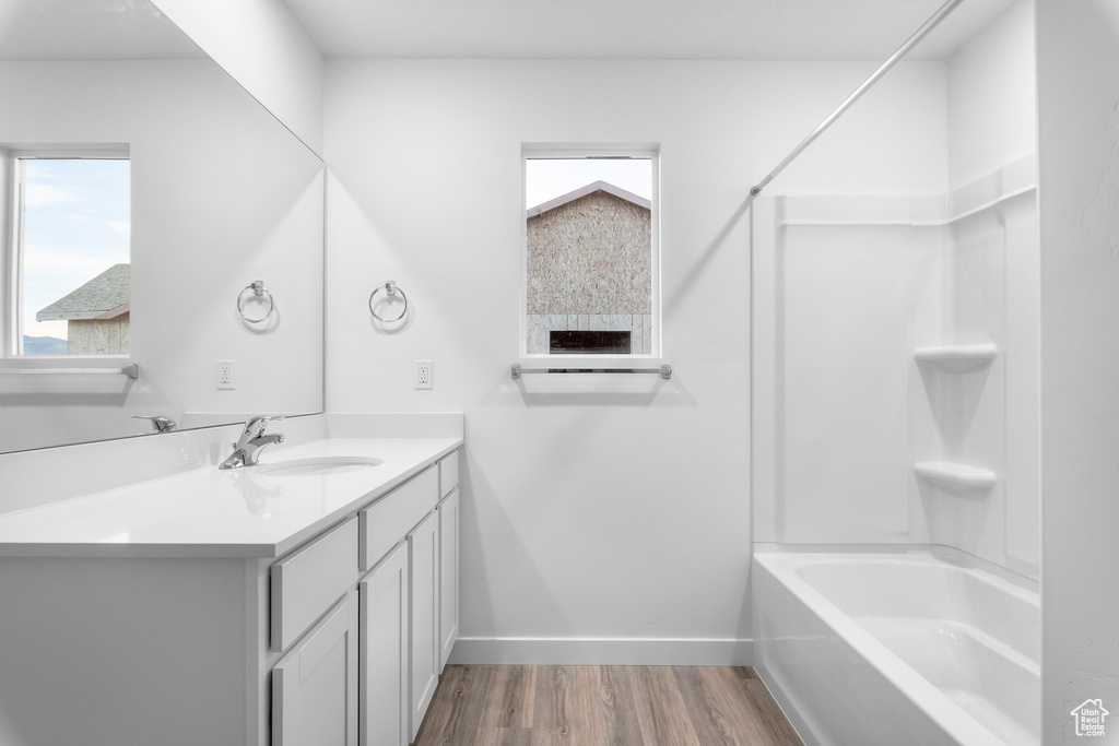 Bathroom featuring shower / washtub combination, vanity, and hardwood / wood-style floors