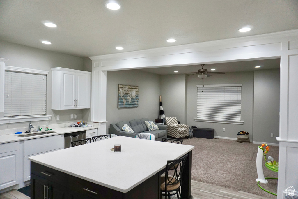 Kitchen featuring light carpet, white cabinetry, sink, dishwasher, and ceiling fan