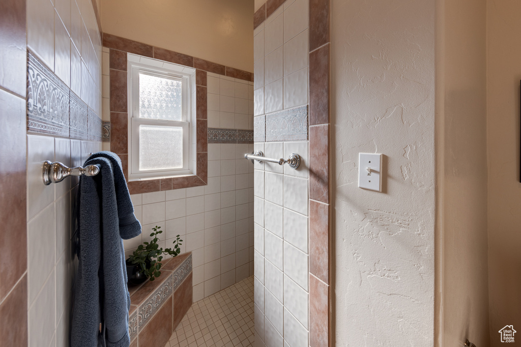 Bathroom featuring tile walls and a tile shower
