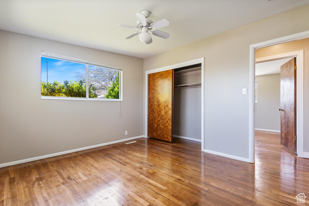 Unfurnished bedroom featuring a closet, ceiling fan, and hardwood / wood-style floors