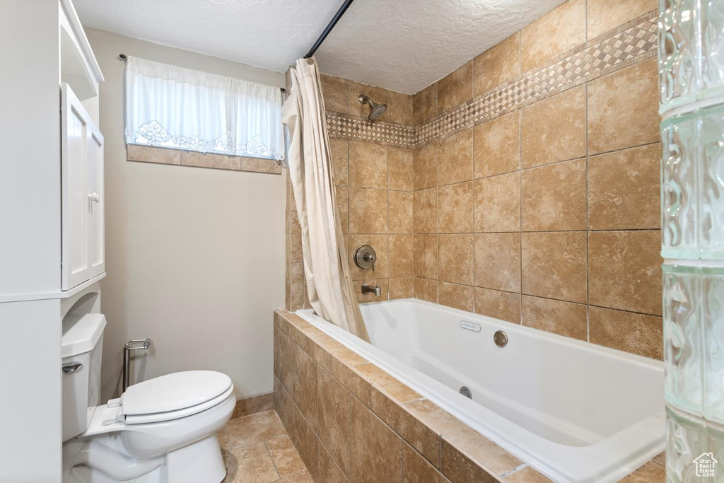 Bathroom with toilet, tile flooring, and shower / bath combination with curtain