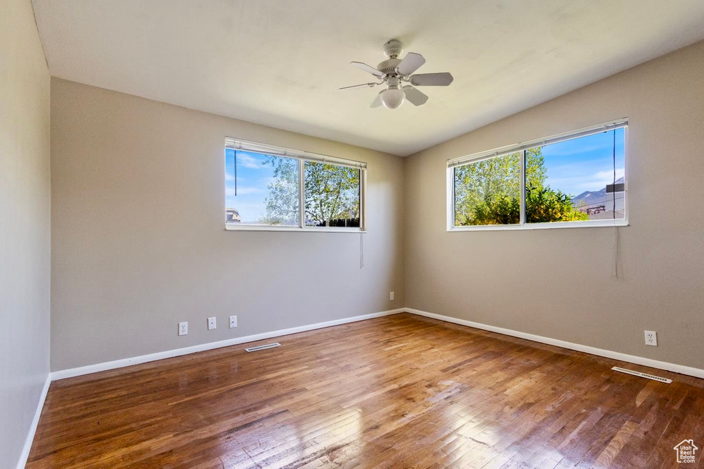 Unfurnished room with vaulted ceiling, hardwood / wood-style floors, and ceiling fan