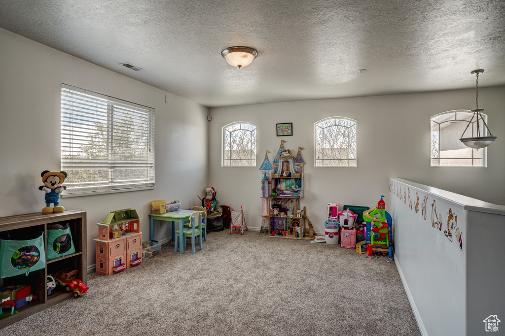 Playroom with carpet and a textured ceiling