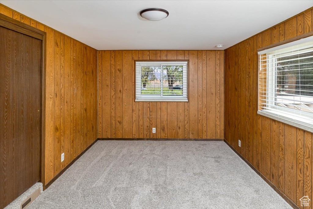 Carpeted empty room with wood walls