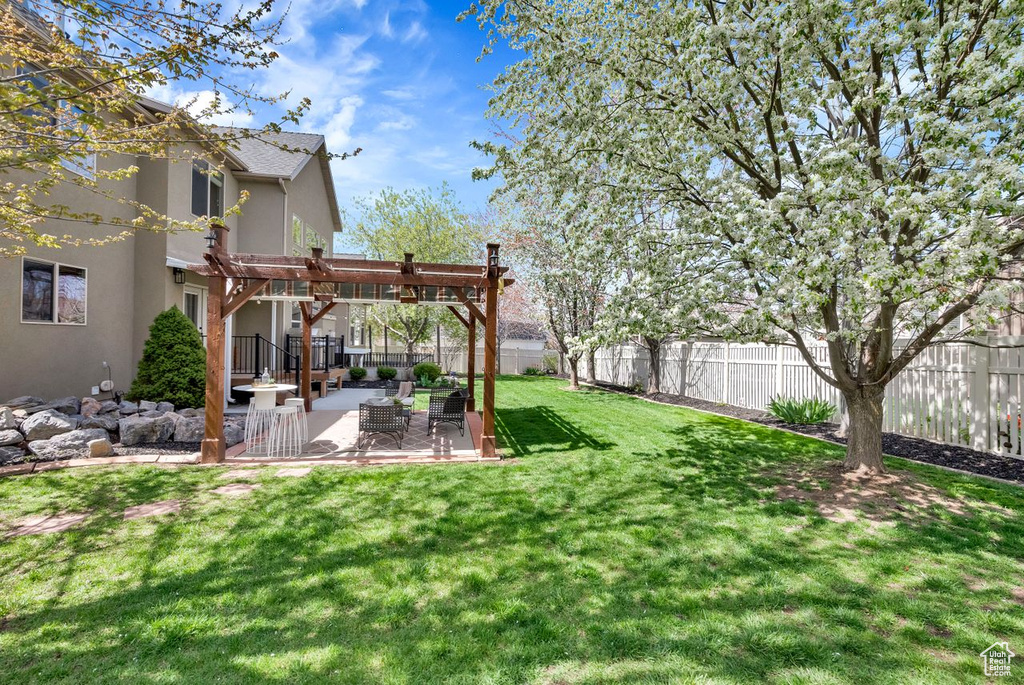 View of yard featuring a patio, a pergola, and an outdoor hangout area