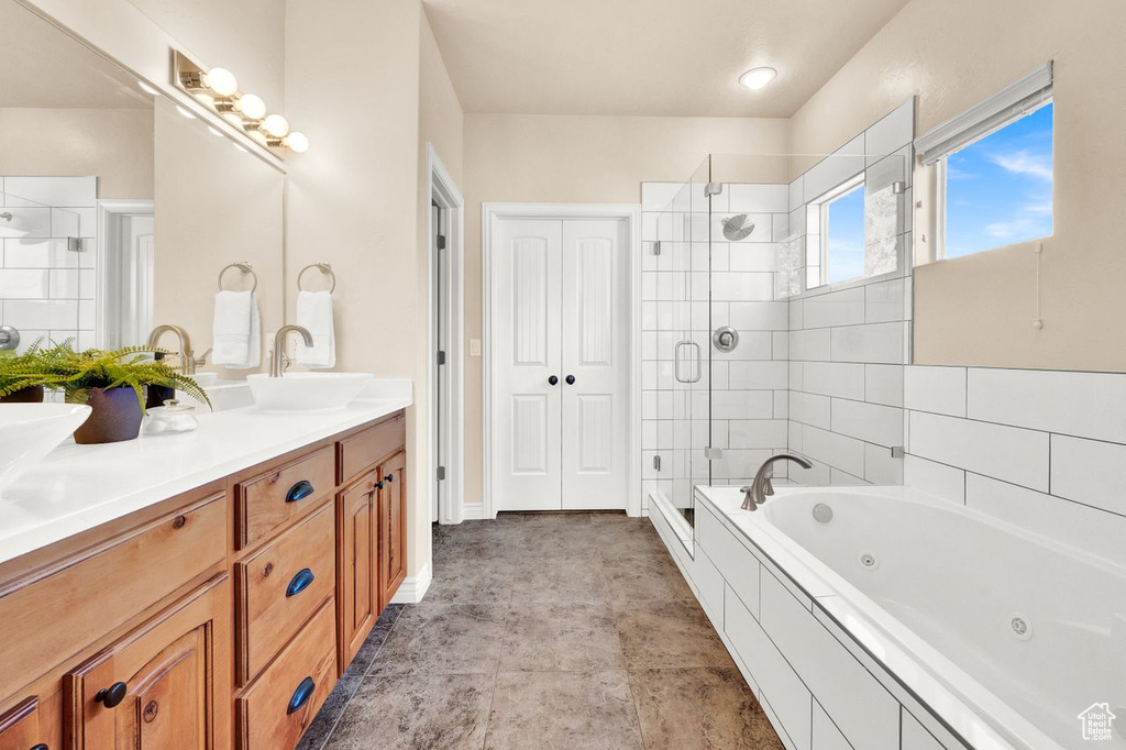 Bathroom with independent shower and bath, tile floors, and double sink vanity