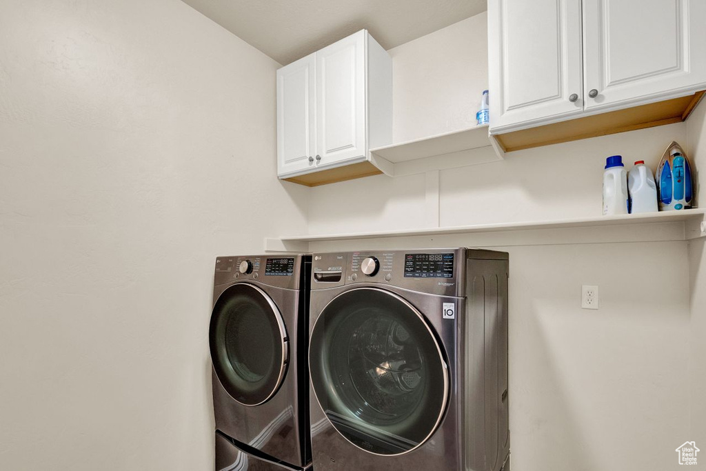 Washroom with cabinets and separate washer and dryer