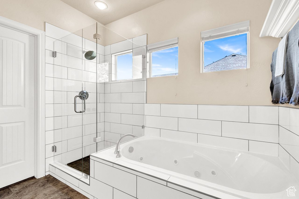 Bathroom with wood-type flooring and separate shower and tub