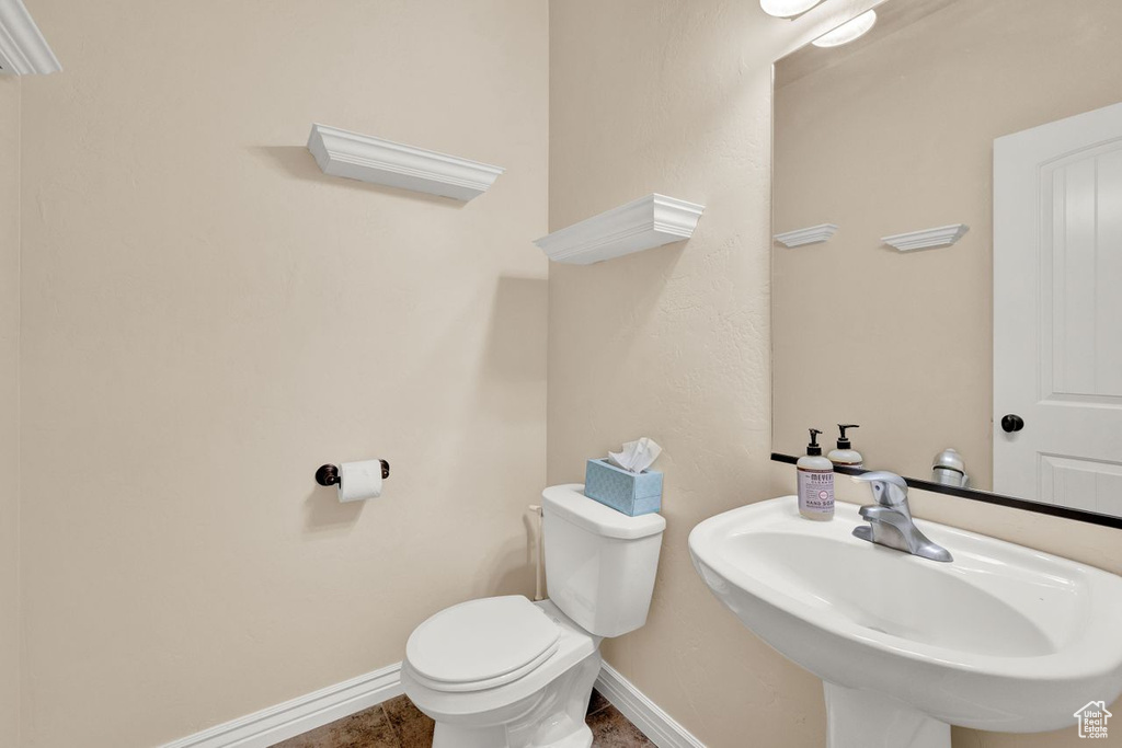 Bathroom featuring toilet, tile floors, and sink