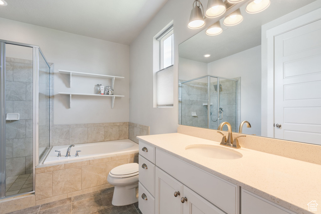 Full bathroom featuring oversized vanity, separate shower and tub, toilet, and tile flooring