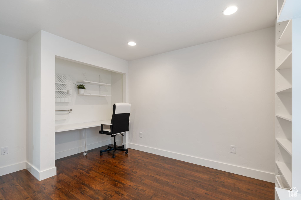 Unfurnished office with built in desk and dark hardwood / wood-style floors