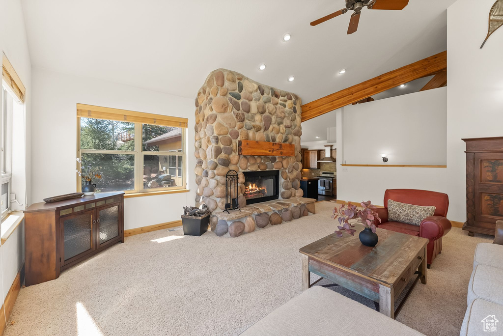 Living room featuring a fireplace, ceiling fan, carpet, and vaulted ceiling with beams
