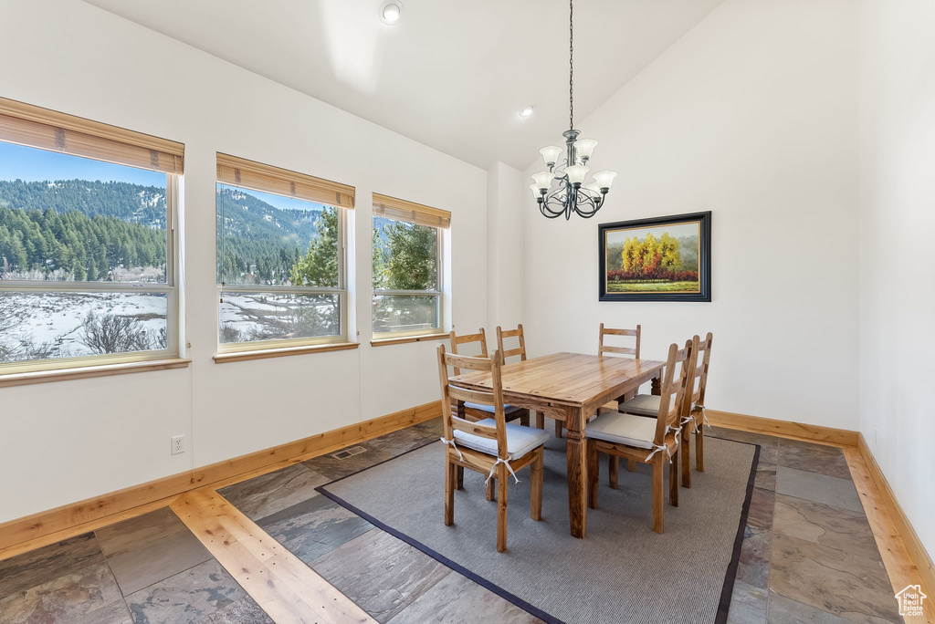 Dining space featuring wood-type flooring, high vaulted ceiling, a mountain view, and an inviting chandelier