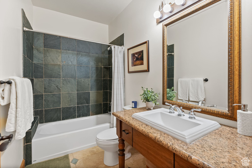 Full bathroom featuring vanity, shower / tub combo, toilet, and tile flooring