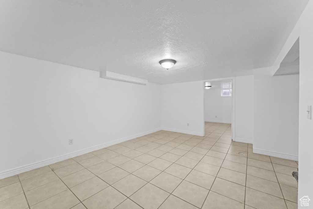 Unfurnished room featuring light tile floors and a textured ceiling