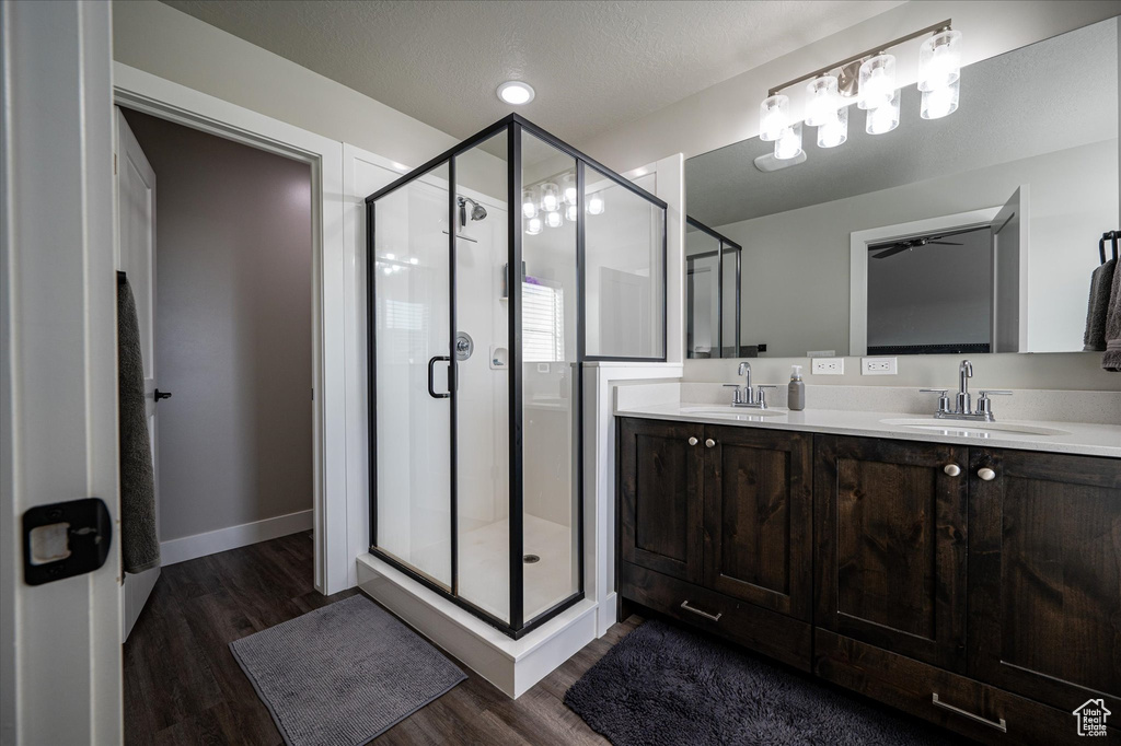 Bathroom featuring walk in shower, hardwood / wood-style flooring, and dual sinks