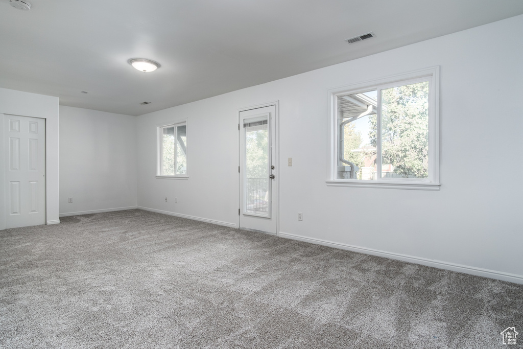 Unfurnished room with plenty of natural light and carpet floors