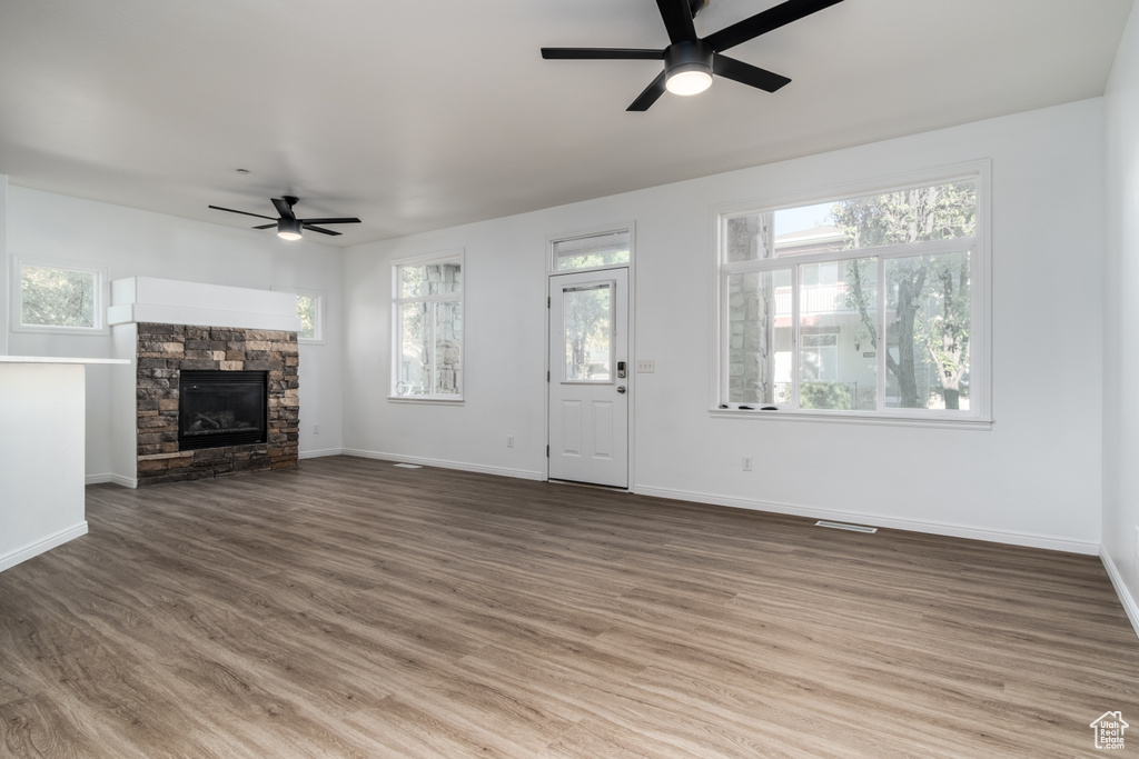 Unfurnished living room with ceiling fan, hardwood / wood-style flooring, and plenty of natural light