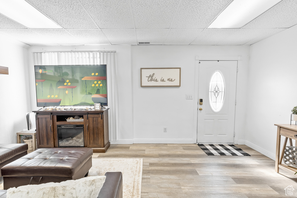 Entryway with light hardwood / wood-style floors and a paneled ceiling