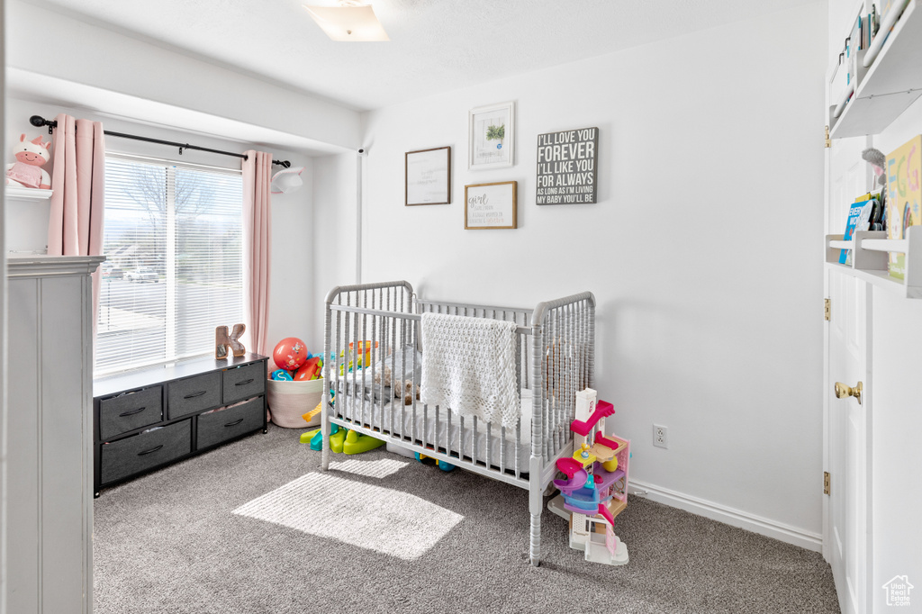 Bedroom with carpet flooring and a nursery area
