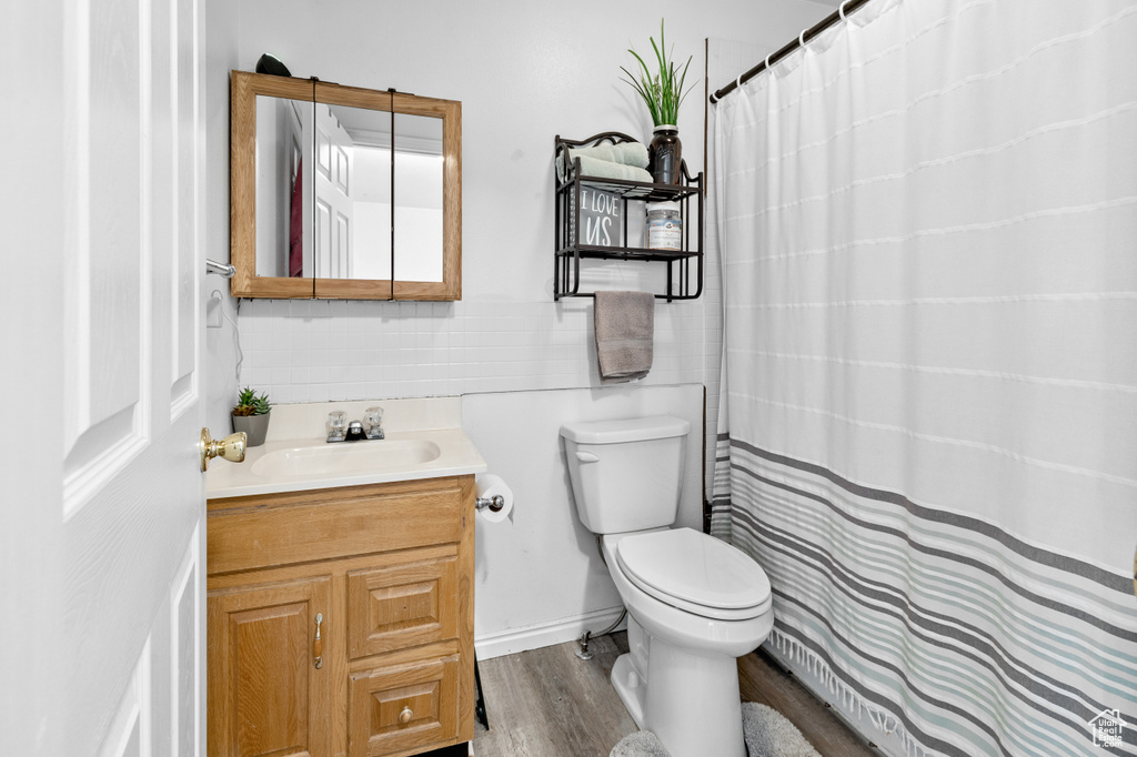 Bathroom with toilet, hardwood / wood-style floors, and large vanity