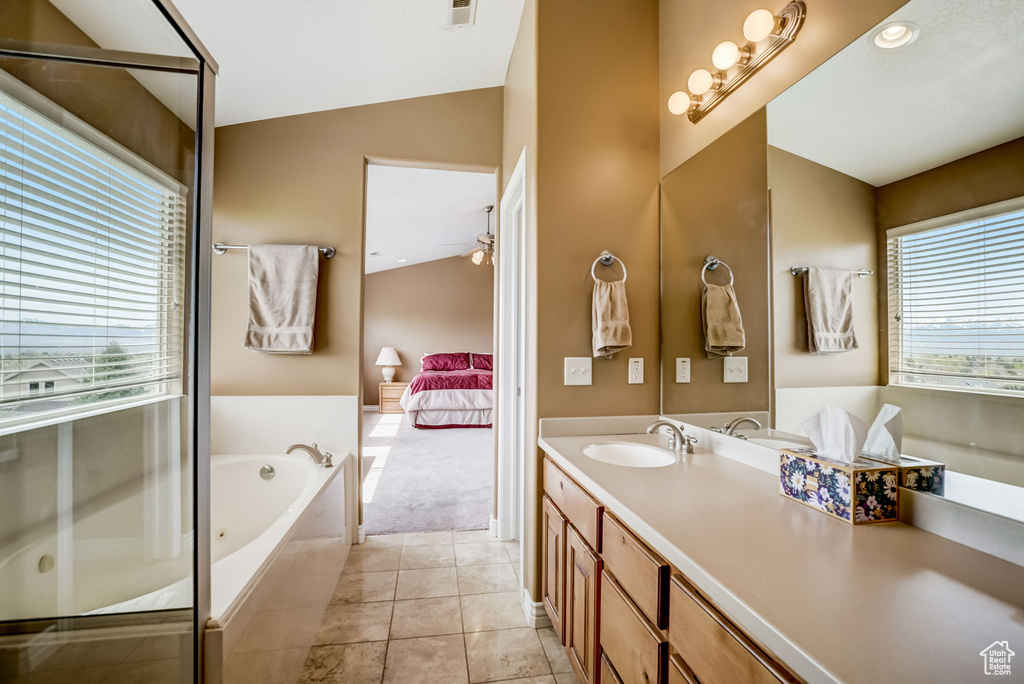Bathroom featuring tile floors, large vanity, vaulted ceiling, ceiling fan, and plus walk in shower