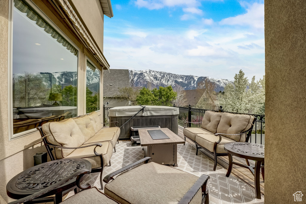 Balcony featuring a hot tub, a mountain view, and an outdoor hangout area