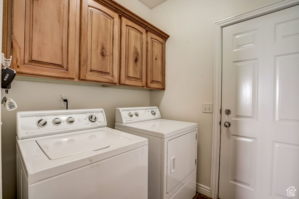 Laundry area featuring cabinets and washing machine and clothes dryer