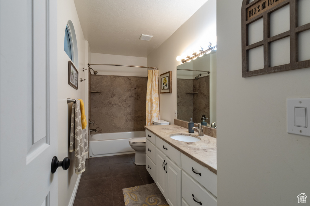 Full bathroom featuring tile flooring, oversized vanity, toilet, and shower / bath combo with shower curtain