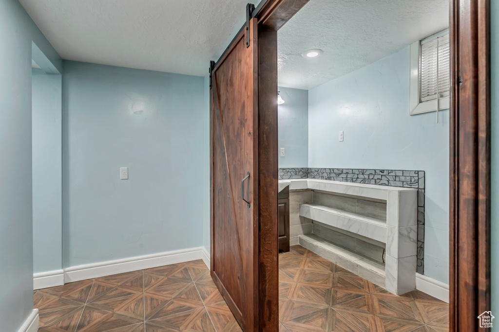 Bathroom featuring parquet flooring and a textured ceiling