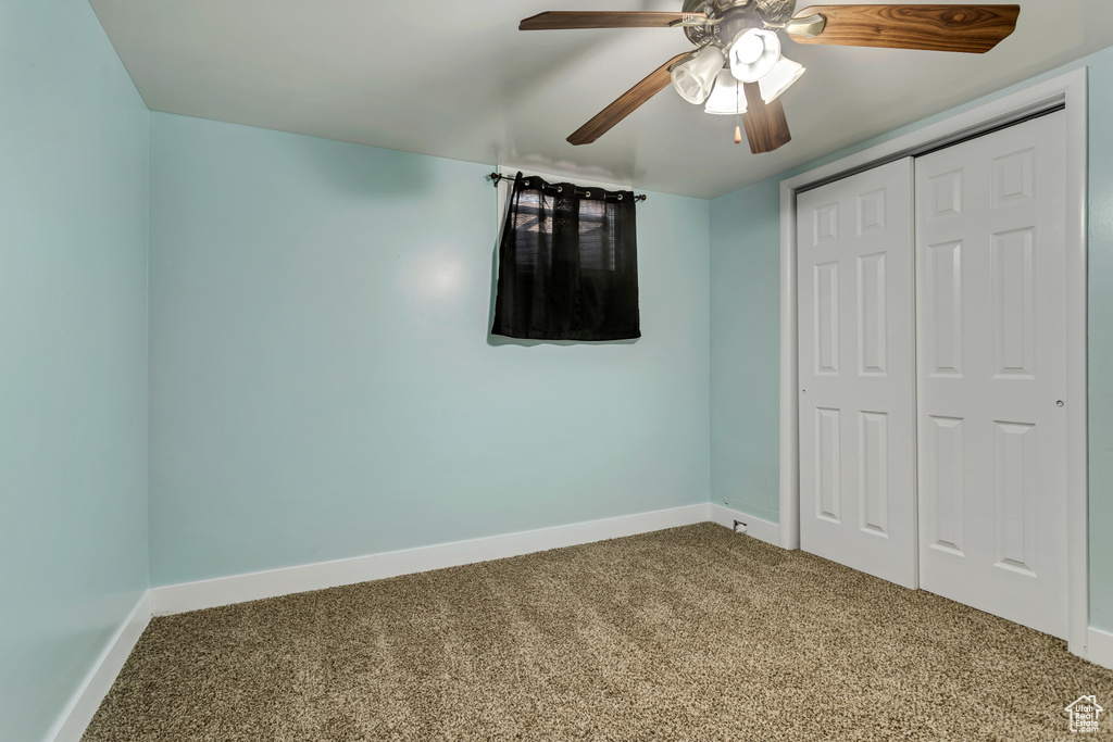 Unfurnished bedroom featuring a closet, ceiling fan, and carpet