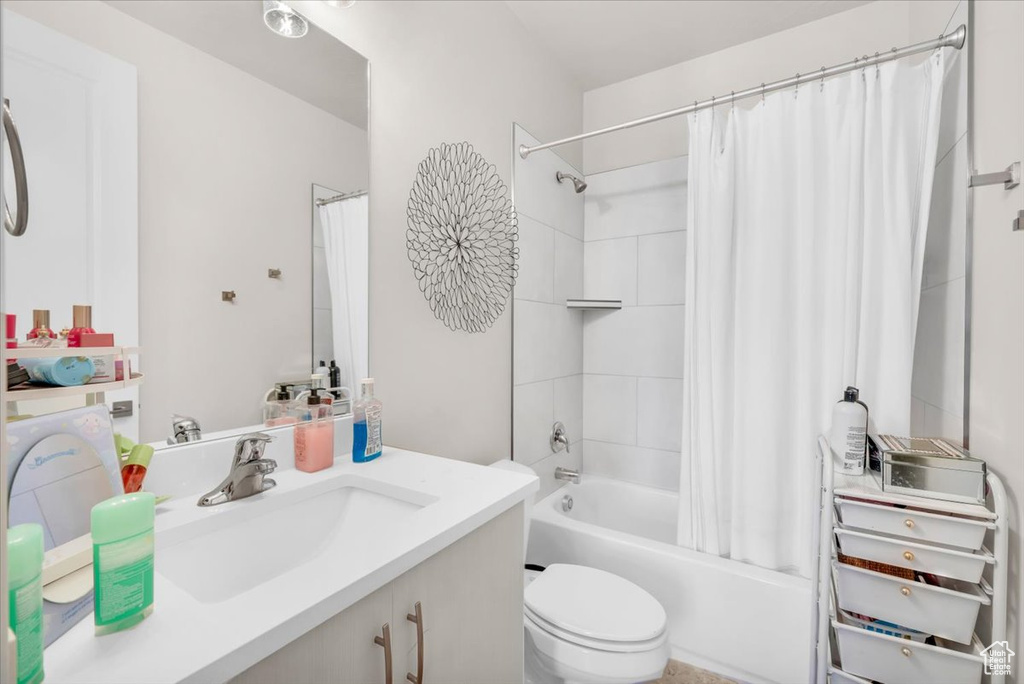 Full bathroom with shower / bath combo, vanity, and toilet
