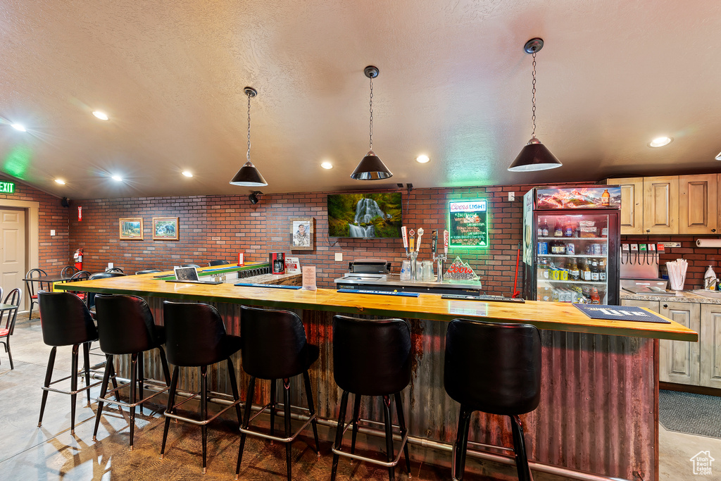 Bar featuring pendant lighting and butcher block counters