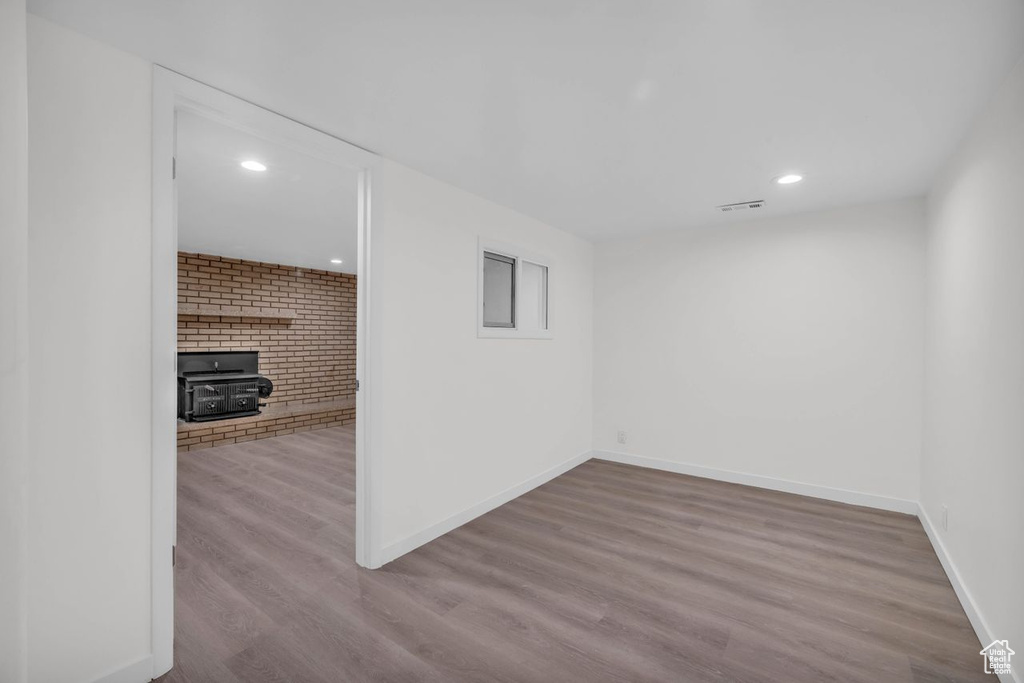Unfurnished room with brick wall and hardwood / wood-style flooring