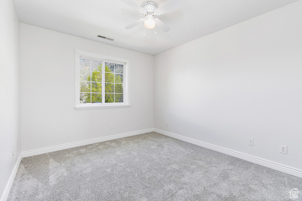 Empty room with ceiling fan and carpet floors