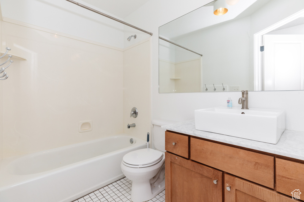 Full bathroom with vanity with extensive cabinet space, bathing tub / shower combination, tile floors, and toilet