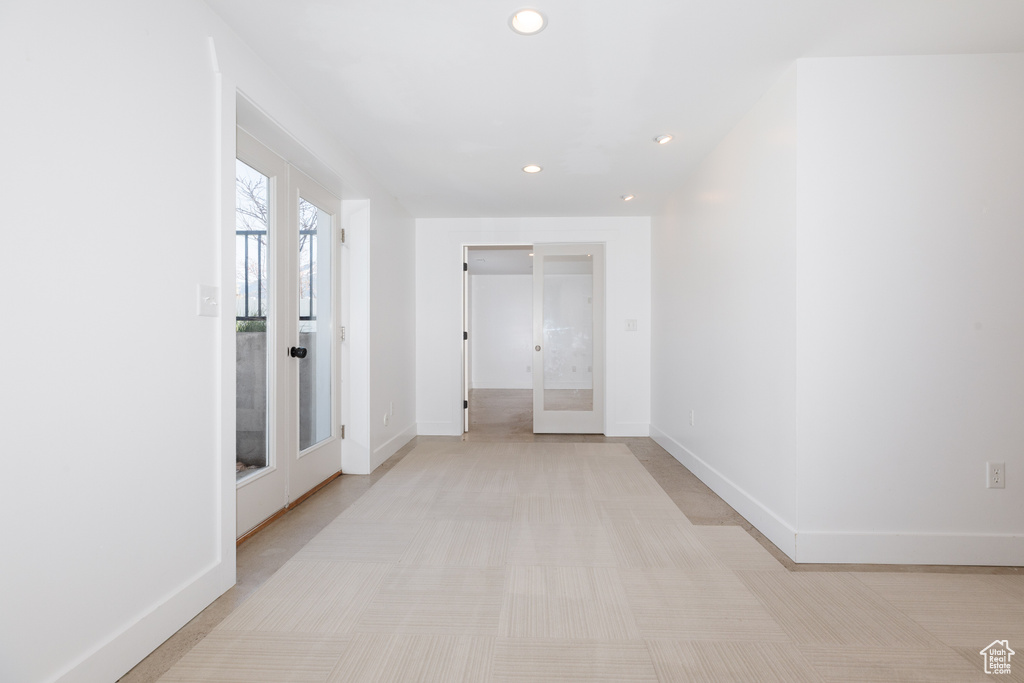Hallway with french doors and light tile flooring
