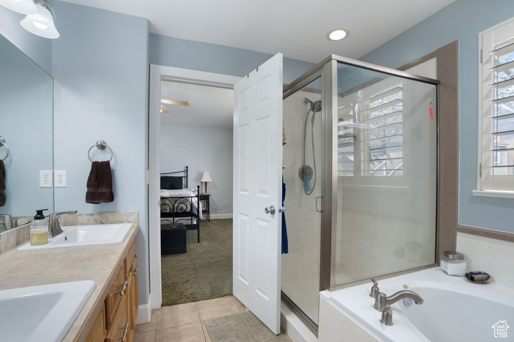 Bathroom with plenty of natural light, shower with separate bathtub, and tile flooring