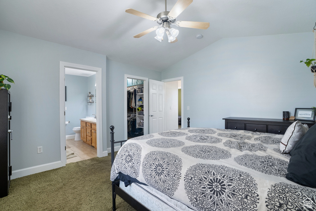 Carpeted bedroom with a spacious closet, ceiling fan, lofted ceiling, a closet, and connected bathroom