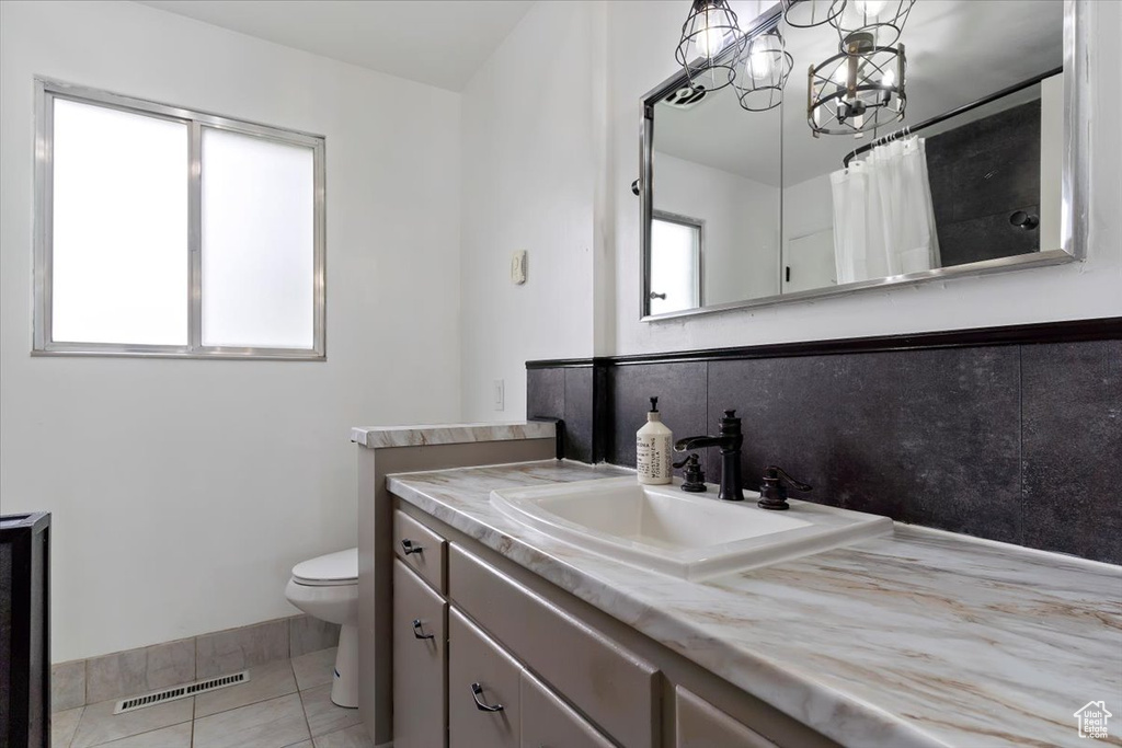 Bathroom with tile flooring, oversized vanity, and toilet