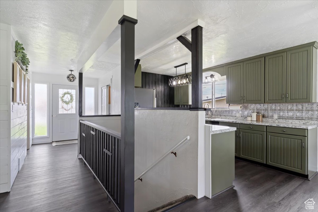 Kitchen with plenty of natural light, stainless steel fridge, pendant lighting, and dark hardwood / wood-style floors