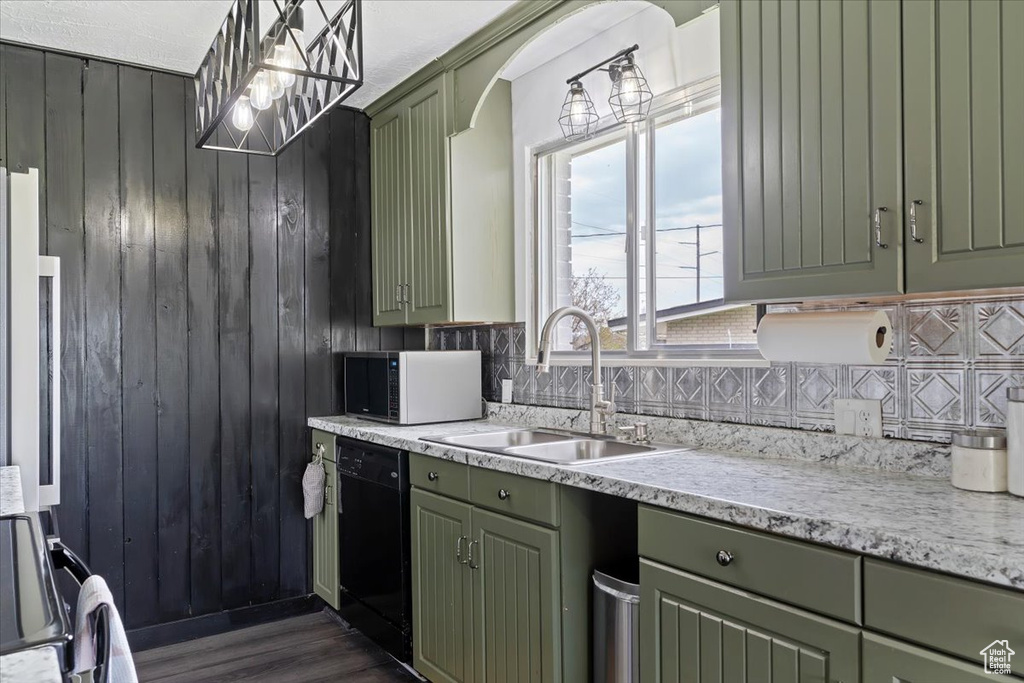 Kitchen featuring sink, tasteful backsplash, dark hardwood / wood-style flooring, black dishwasher, and green cabinetry