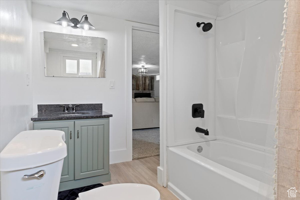Full bathroom with vanity, hardwood / wood-style flooring, toilet, and shower / bathtub combination with curtain