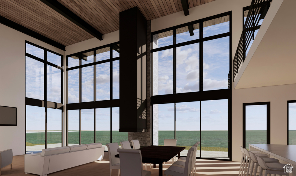 Dining area featuring wood ceiling, a healthy amount of sunlight, a towering ceiling, and a water view
